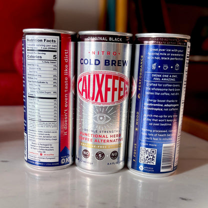 Three Cauxffee drink cans on a marble surface with a blurred background